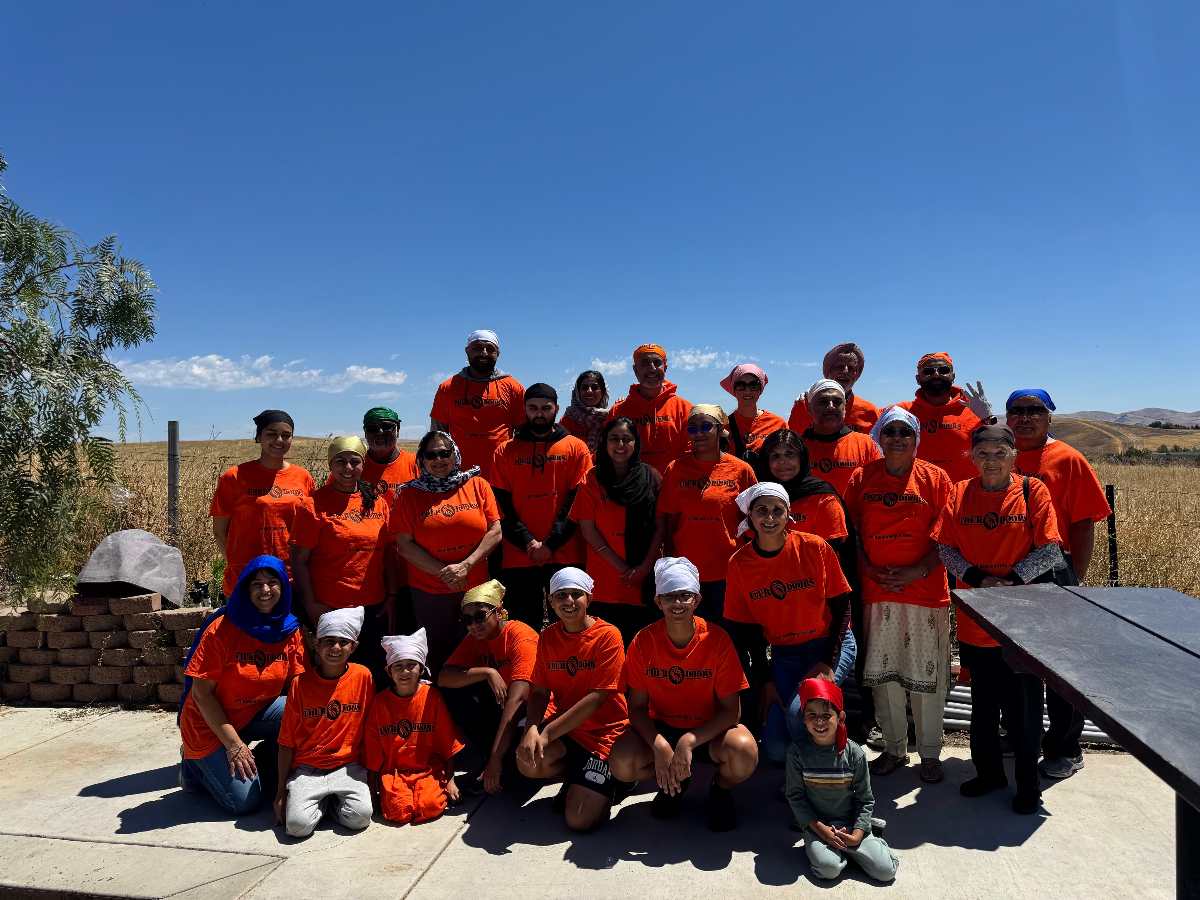 Four Doors volunteers in orange shirts gathered together